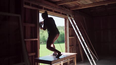 a man with electric saw repairing wooden window frame