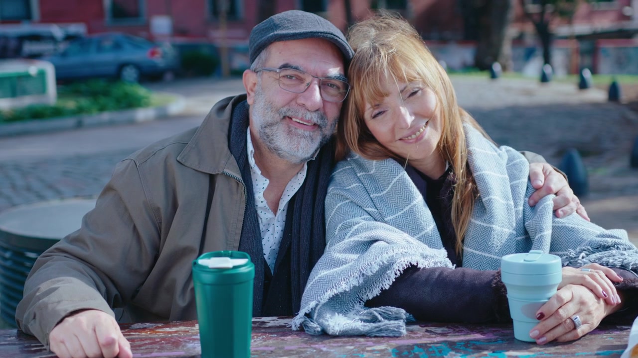Ritratto di coppia anziana affettuosa con caffè al parco