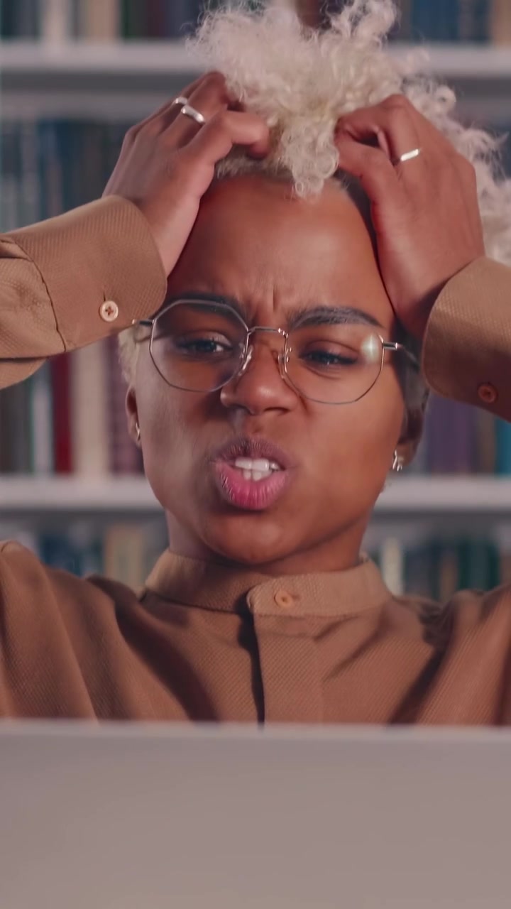 Frustrated african american student in glasses clutching her hair in front of