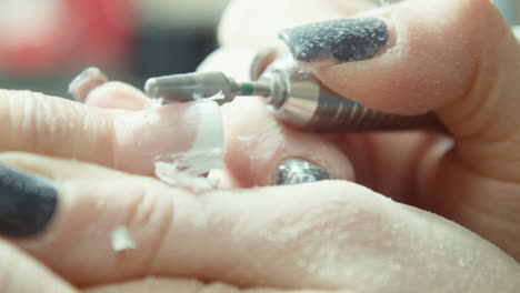 nail technician filing acrylic nails