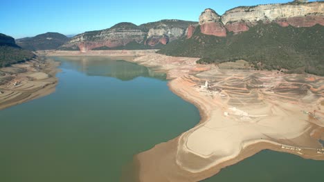 Sau-swamp-dike-in-Catalonia,-Spain,-intense-drought-in-2024-erial-views-of-the-scarce-water-reserves-left-in-Europe