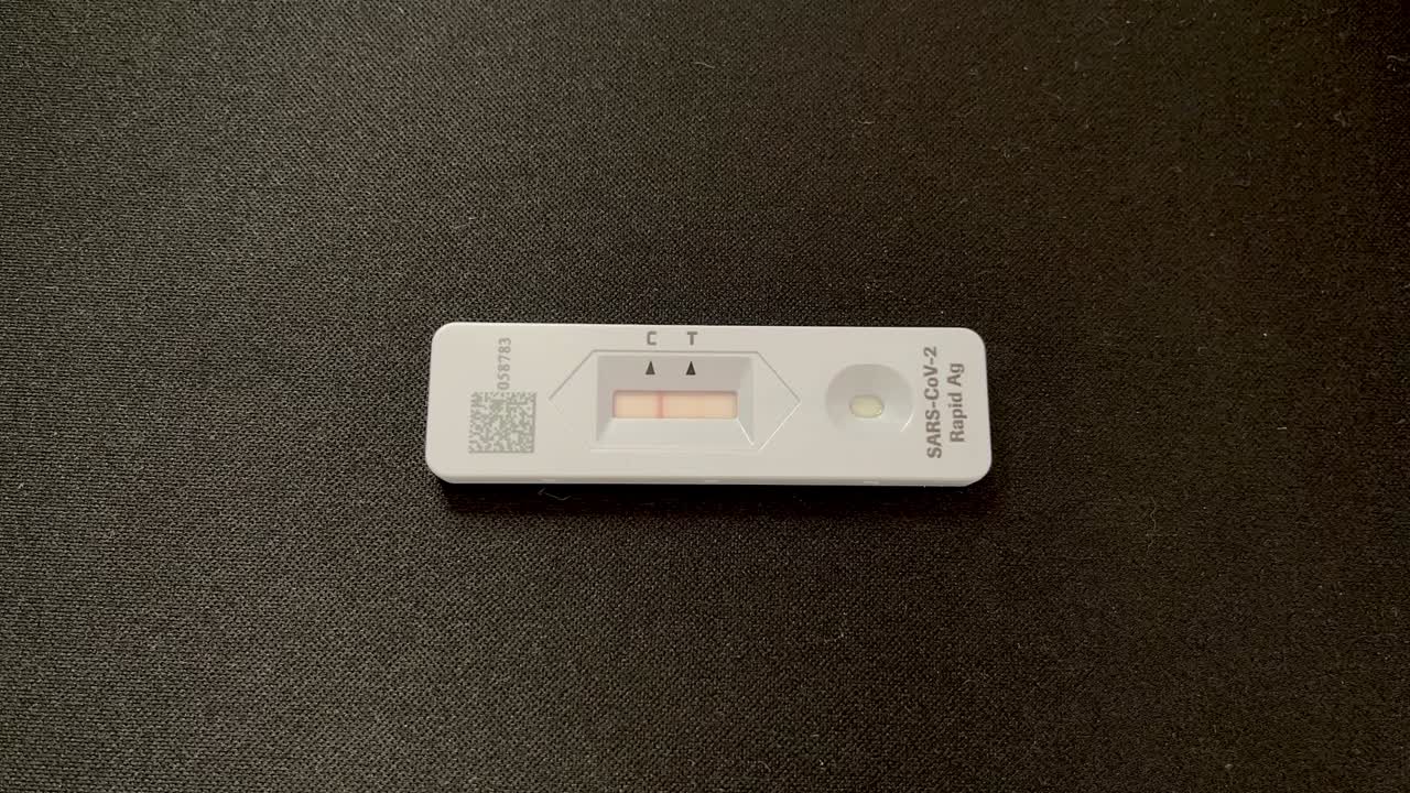 Time lapse of Positive Rapid COVID 19 Antigen Test on black background