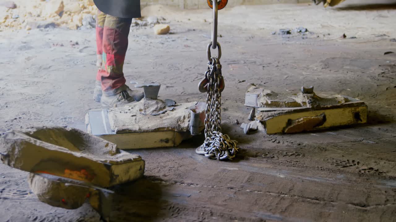 hombre que usa una grúa aérea en un taller de fundición 4k