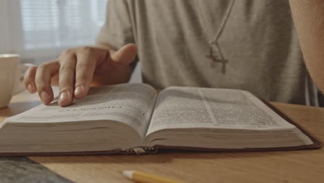 Primer-Plano-De-Un-Hombre-Cristiano-Leyendo-Cuidadosamente-La-Biblia,-Moviendo-Los-Dedos-A-Lo-Largo-De-Las-Líneas-De-Texto