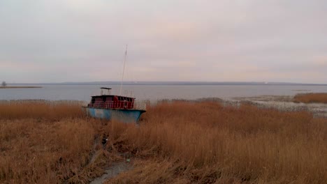 golden grass reveals rusty shipwreck at dabie lake in lubczyna, poland