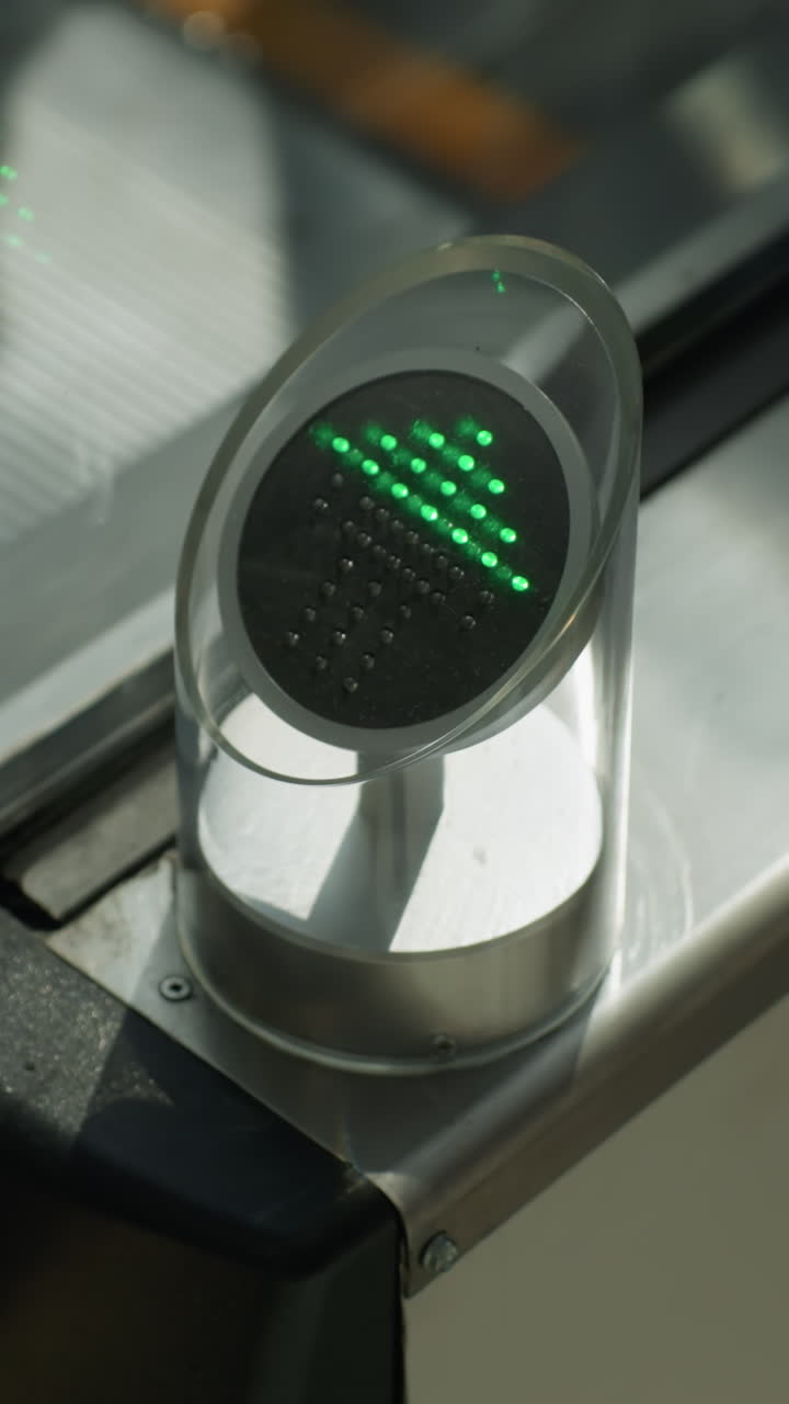 una vista muy cercana que captura el detalle de los escalones mecánicos y una persona que baja. el enfoque está en las partes mecánicas y la luz direccional verde