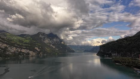 hyperlapse drone footage over lake walensee, showcasing a beautiful scene with abundant clouds and snow-capped mountains in the background.