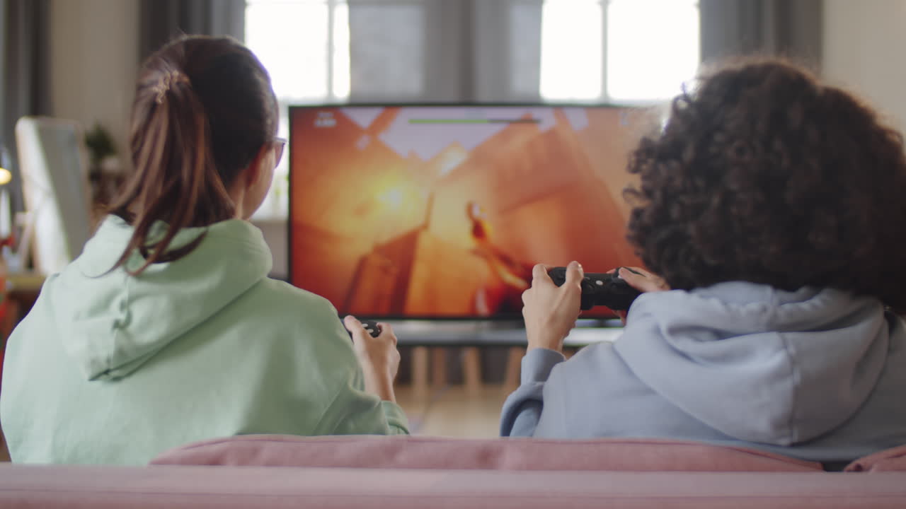 Ragazzo e ragazza adolescenti che giocano a un videogioco in TV a casa