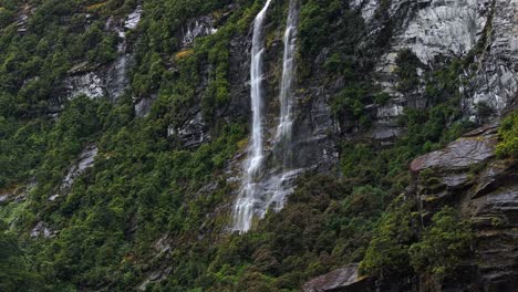 Luftaufnahmen-Schwenken-über-Einen-Wasserfall,-Der-Entlang-Weißer-Felsen-Und-Tropischer-Vegetation-Herabfällt