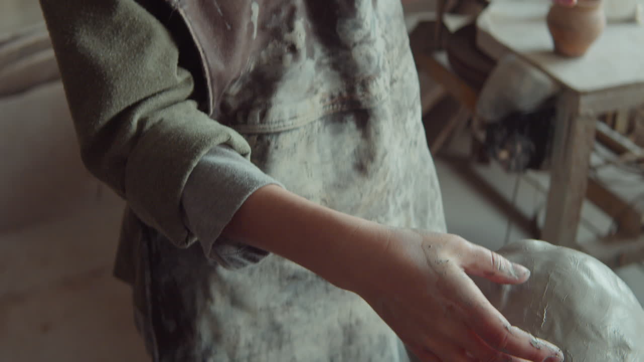 escultora que trabaja con cabeza de arcilla en el estudio