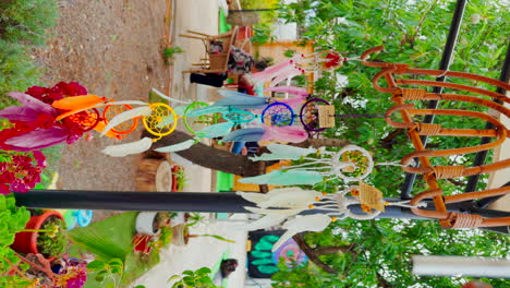 colorful dream catchers representative of the chakras with feathers hanging in an outdoor tent moving with the wind