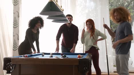 friends playing pool together in game room on weekend