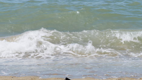 waves rushing splashing towards the shore and sand as bubbles revealed on the shoreline of a beach in pattaya, thailand