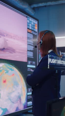 boss and employees watching successful launch of rocket on large screen then applauding and giving high five during work in flight control center. vertical shot