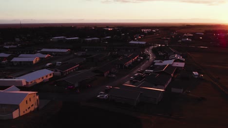 houses of beautiful town hvolsvöllur, iceland aerial during golden sunset, flying over