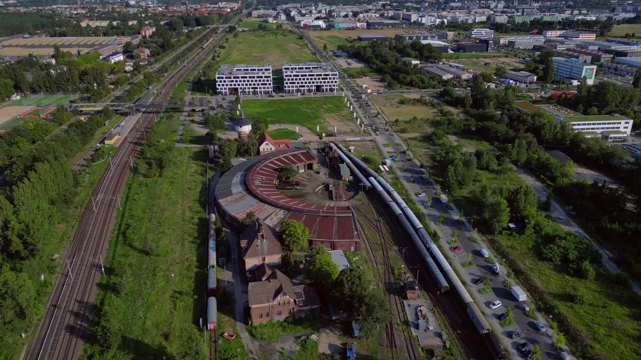 historic steam locomotive shed and trains depot with surrounding urban city Berlin Germany landscape, industrial heritage. Perfect aerial view flight wide orbit overview drone