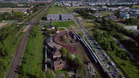historic steam locomotive shed and trains depot with surrounding urban city berlin germany landscape, industrial heritage. perfect aerial view flight wide orbit overview drone