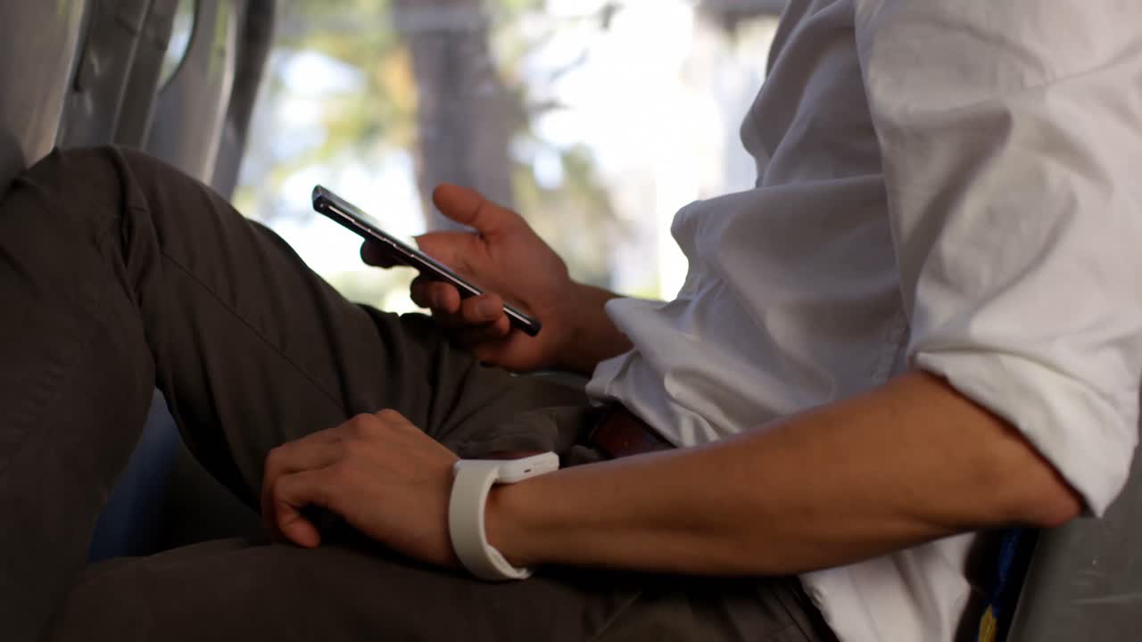 Male commuter using mobile phone while travelling in bus 4k