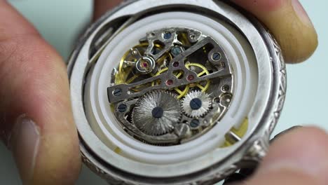 old pocket watch mechanism working, close up view