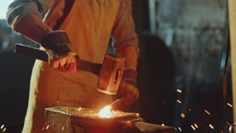 blacksmith doing hot metalwork on anvil in the workshop