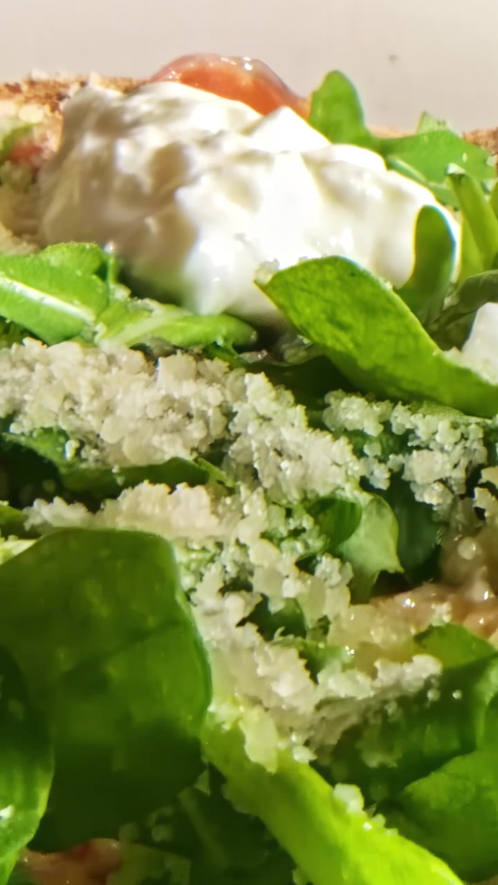 Deliziosa pizza gourmet con rucola fresca e burrata cremosa in vista macro dettagliata