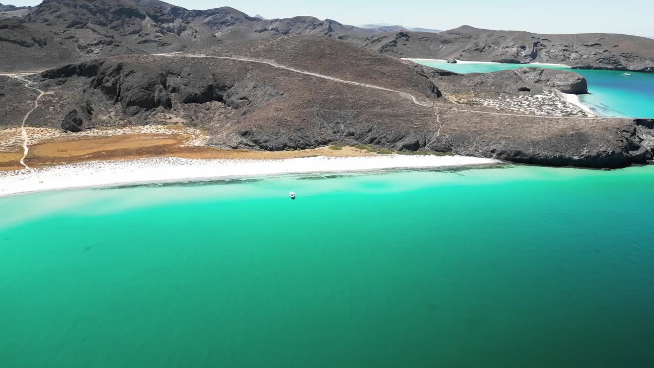 Serene beach view of Tecolotito, La Paz, with clear turquoise waters and mountains