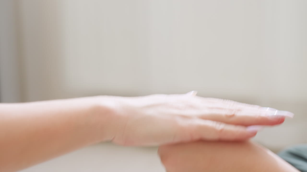 Close up of child and adult hands engaging in playful hand trick indoors with blurred background, showcasing movement, coordination, and fun interaction in cozy home environment