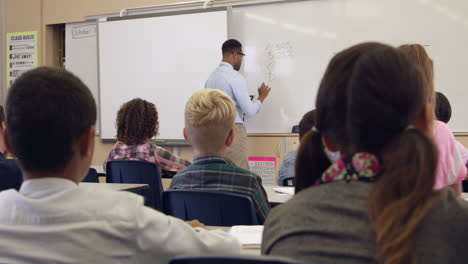 clase de matemáticas de quinto grado mira a la maestra, vista trasera, filmada en r3d