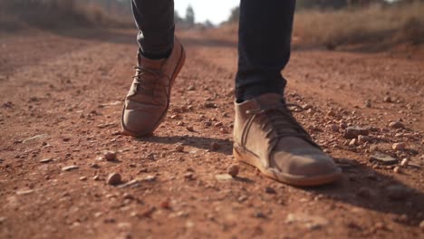 Botas-De-Cuero-Marrón-Caminando-Por-Un-Camino-De-Tierra