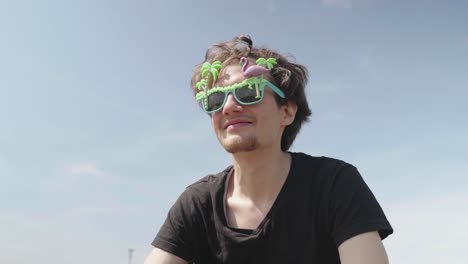 un joven se pone unas gafas de colores locas y se mueve al ritmo de una música