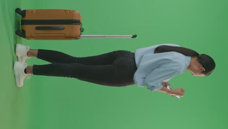 woman with luggage and mobile phone on green screen