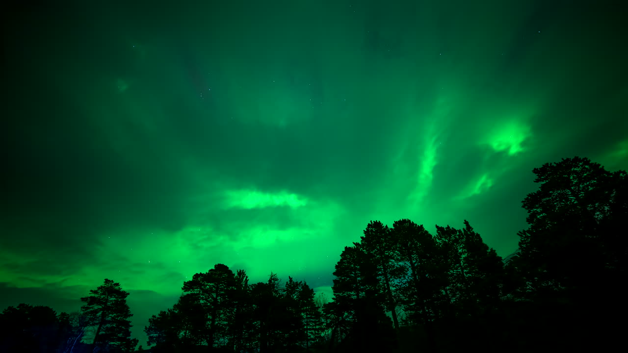 Otherworldly time lapse night sky scene with magical green northern lights