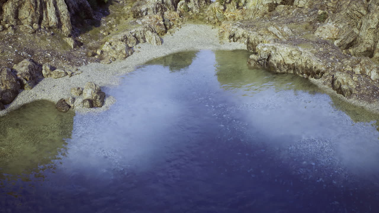 Clear water reflects rocky shoreline in serene natural setting