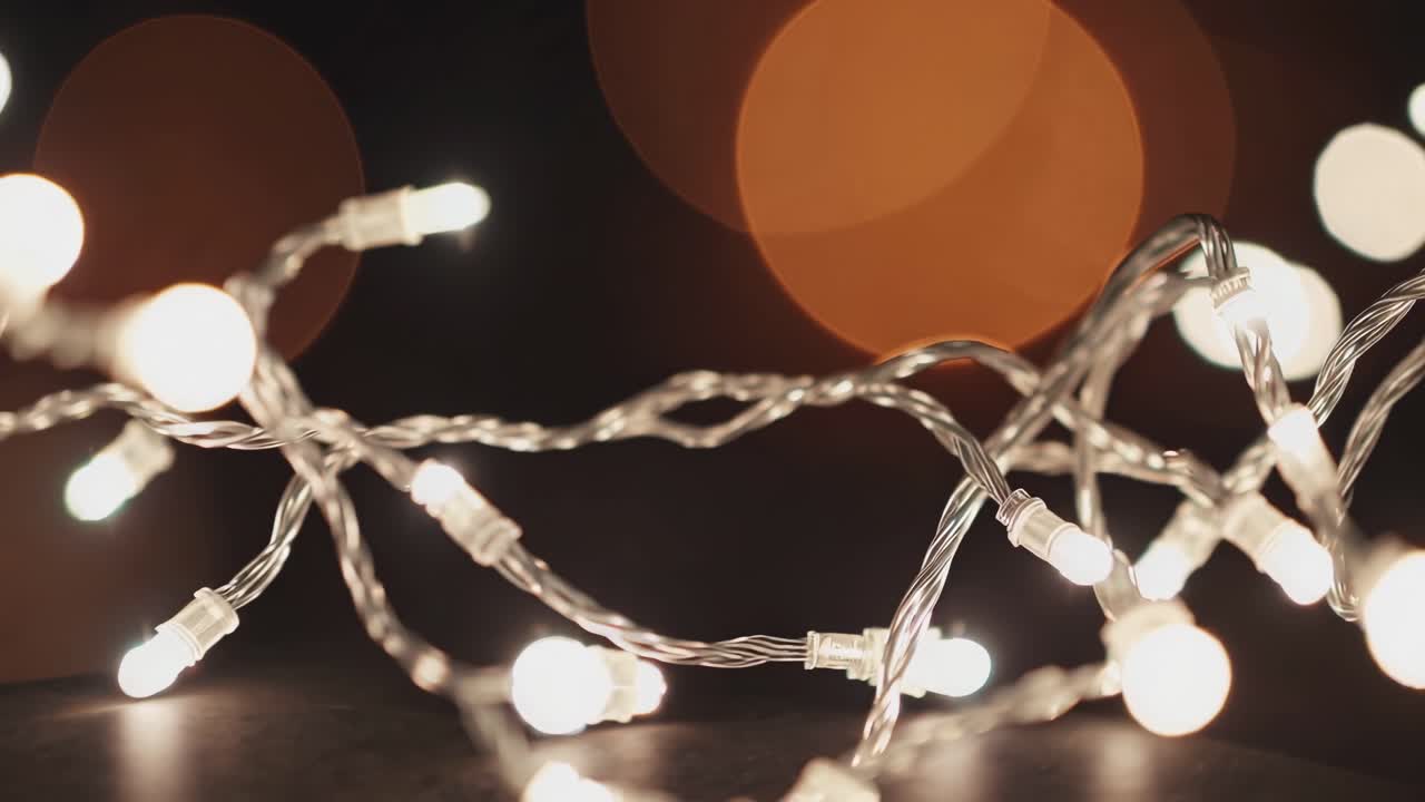 Close-up video of glowing string lights with a bokeh effect, shot from a low angle