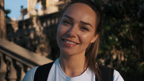 la cámara haciendo zoom en la mujer de fútbol sonriendo a la cámara en la calle.