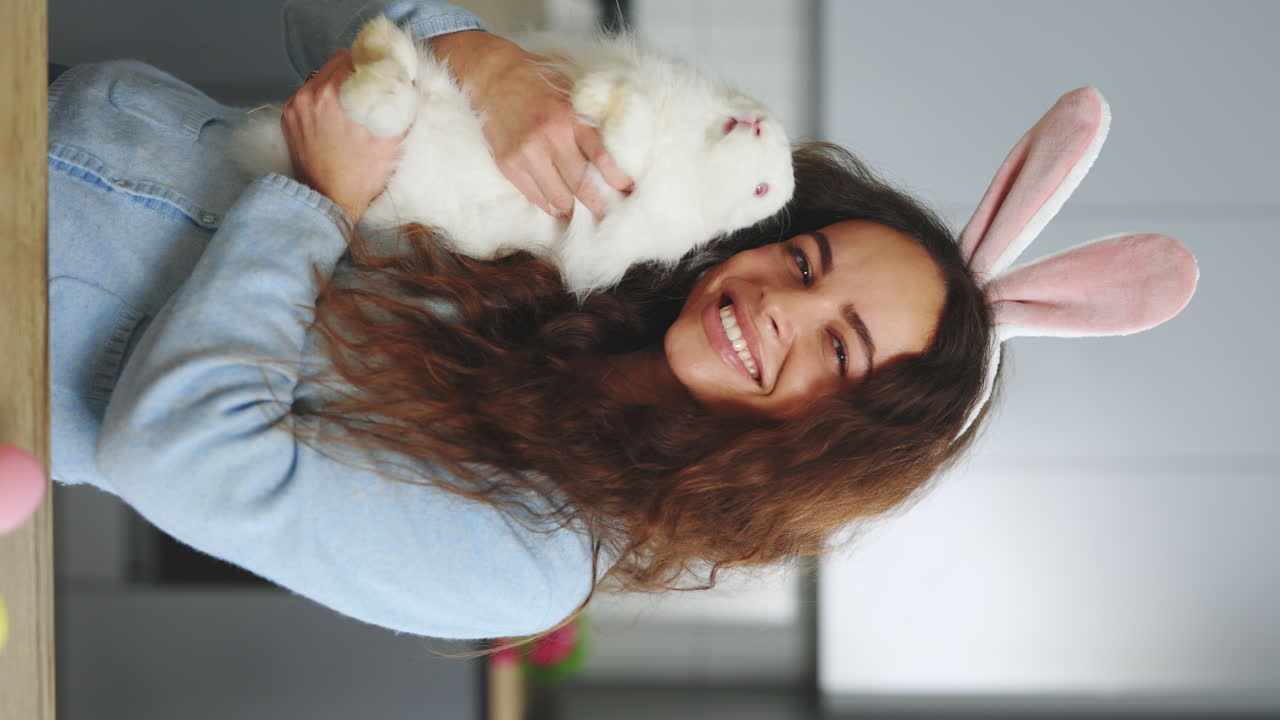 Woman holding a rabbit with Easter bunny ears