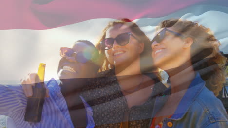 Composite-Video-Einer-Wehenden-Niederländischen-Flagge-über-Verschiedenen-Mädchen,-Die-Im-Freien-Neben-Einem-Auto-Ein-Selfie-Machen