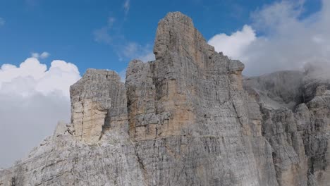 Cinematic-drone-shot-through-dense-clouds-revealing-rocky-mountains-in-Italian-Dolomites