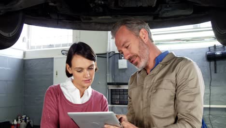 Mechanic-showing-customer-the-problem-with-car