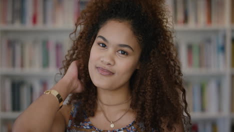 portrait-beautiful-young-mixed-race-woman-smiling-running-hand-through-hair-looking-confident-female-in-bookshelf-background-slow-motion