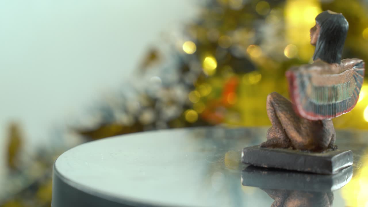 increíble primer plano de una estatua de cleopatra con alas abiertas, profundidad de campo dorada borrosa, antigua, gobernante histórico egipcio, obra de arte antigua de una diosa, girando 360 vídeo suave 4k pan a la derecha