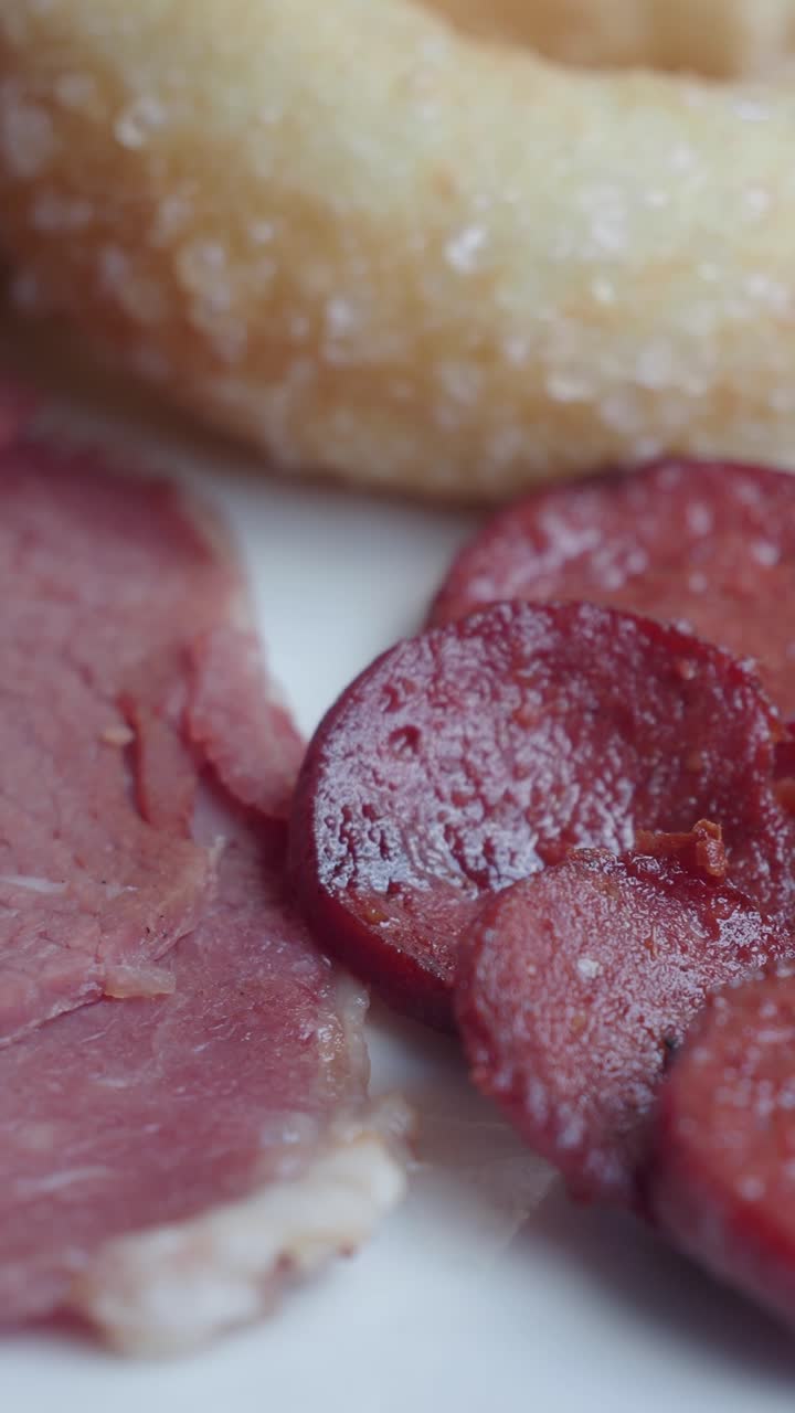 Primo piano di salumi misti per la colazione e dolci da forno.