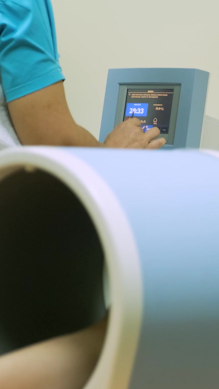 Medical Professional Operating Physiotherapy Device on Patient's Arm