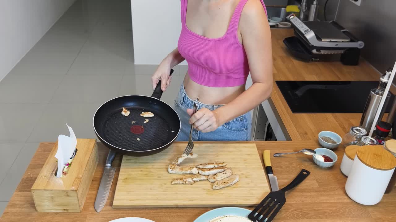 mujer cocinando pollo en una cocina