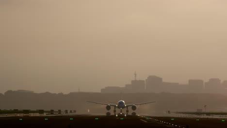 aterrizaje de avión en la pista con el horizonte de la ciudad en el fondo