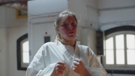 toma de mano de karateka enfocado haciendo patadas de salto a la cámara