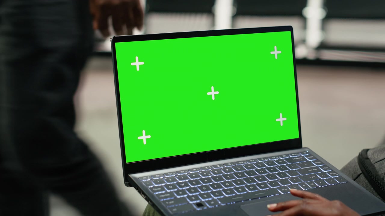 Notebook mockup con schermo verde usato da una donna che lavora in una stazione degli autobus.