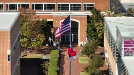 america and north carolina flags waving at university of nc charlotte campus in front of library