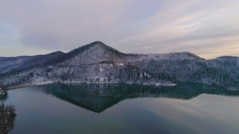 vista aérea del tranquilo lago invernal con reflejo durante la puesta de sol