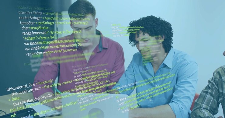 IT-team åbner bærbar computer og peger på kode, mens en grøn pen skriver fejlfindingsnoter, der overlejrer og udvides